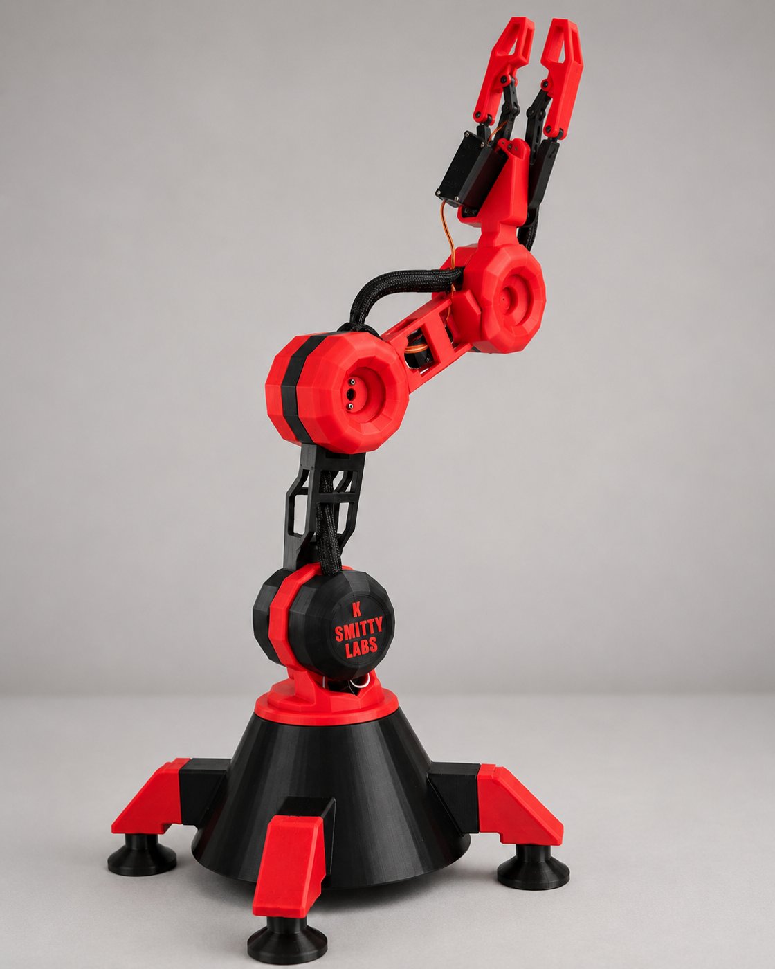 K-Smitty Labs branded robotic arm base on a dark background